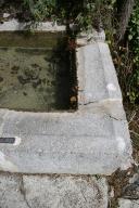 Chaudon-Norante. Fontaine-Lavoir de Chaudon. Les bords chanfreinés de la margelle inclinée dans le bassin de lavage.
