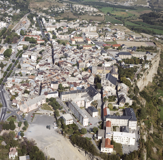 Vue aérienne rapprochée du centre prise de l'ouest. Au premier-plan, angle sud-ouest de l'ancien  périmètre de la ville close, et falaise sud du "Roc".