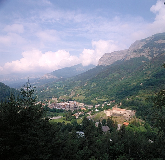 Vue générale prise du nord-est depuis la route du col des Champs. Au centre, en bas, le fort de Savoie. A l'arrière-plan, les falaises de la Barre du Puy.