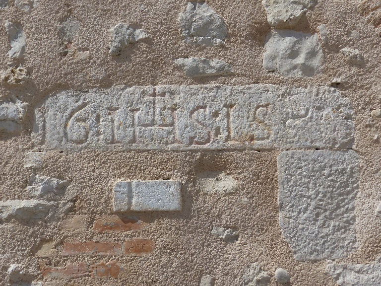 Bâtiment 2. Elévation sud, premier niveau. Ancienne entrée couverte d'un linteau en pierre portant l'inscription : 16 IHS : 15~.