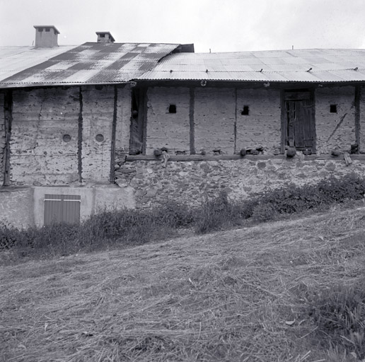 Les Merlins. Façade nord des granges. Vue de détail des pans de bois. Les remplissages sont de nature différente, blancs à gauche, rosés à droite.