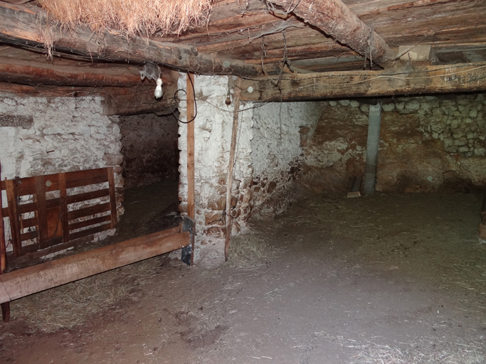 Vue de volume d'une étable dans un bâtiment agricole, pile de fond. Quartier de Mayreste. (1985 W6 311c)