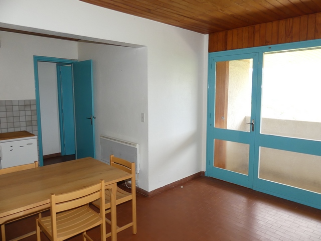 Appartement en rez-de-chaussée surélevé, vue de volume de la pièce à vivre et baie vitrée de la loggia.