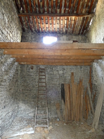 Vue de volume d'un fenil en deuxième et troisième niveaux, entrepôt agricole au bourg.