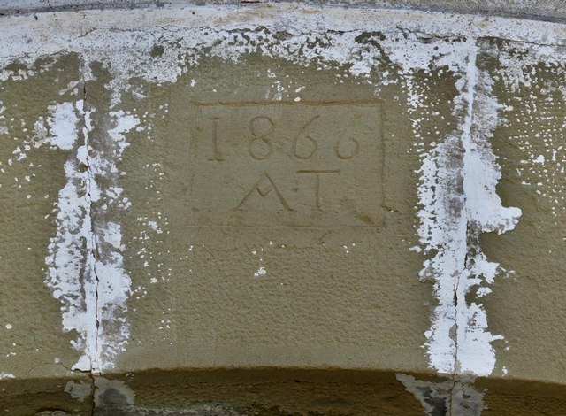 Elévation ouest, premier niveau. Porte charretière, date gravée (1866) accompagnée d'initiales (AT).