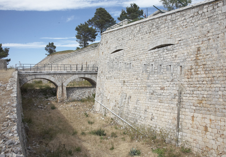 Enceinte : front de gorge ouest vu du sud, face droite du bastion sud-ouest (2), fossé, pont d'accès.