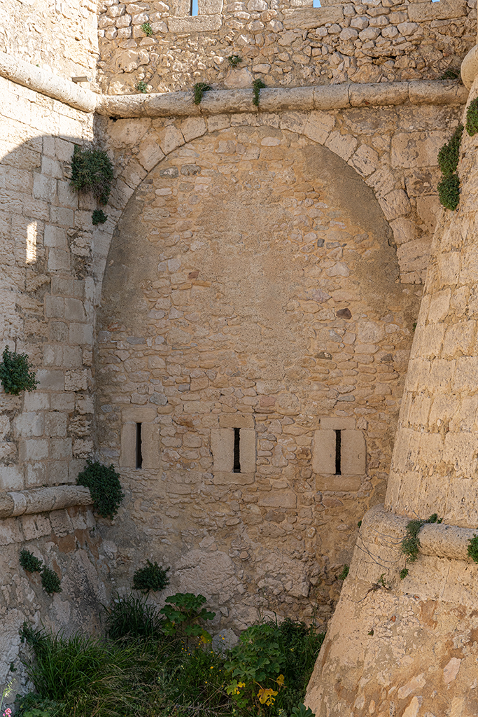 Détail extérieur du demi-bastion de gauche, flanc bas crénelé, arcade, cordon et parapet du chemin de ronde au-dessus, vus de l'étage
