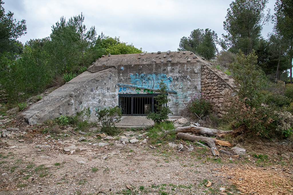 Casemate de flanquement Est, type Regelbau 680, façade active à embrasure et mur de flanquement. Faces latérales enterrées sous remblai 