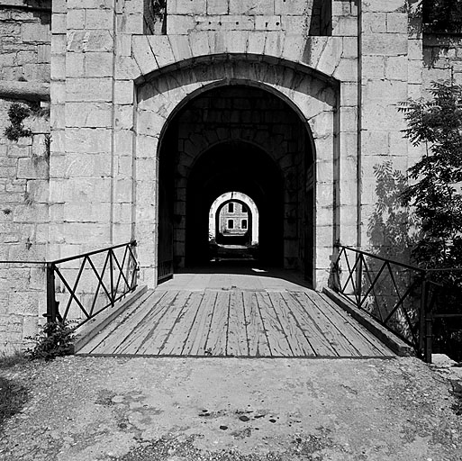 Porte Royale. Travée mobile du pont-levis et partie de la façade : au-dessus du passage, entre les logements des bras du pont-levis, des traces des scellements de la plaque de bronze rappelant la construction sous les ordres de d'Asfeld. Au centre, le passage d'entrée traversant le rempart.