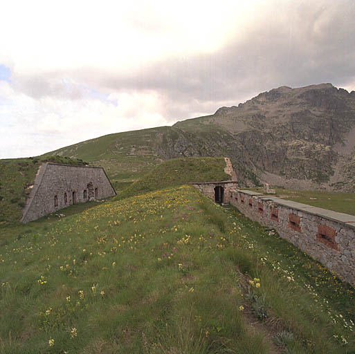 Vue du nord-est : parados, ouvrage d'entrée du fort, rempart nord et son chemin coudé à parapet crénelé.