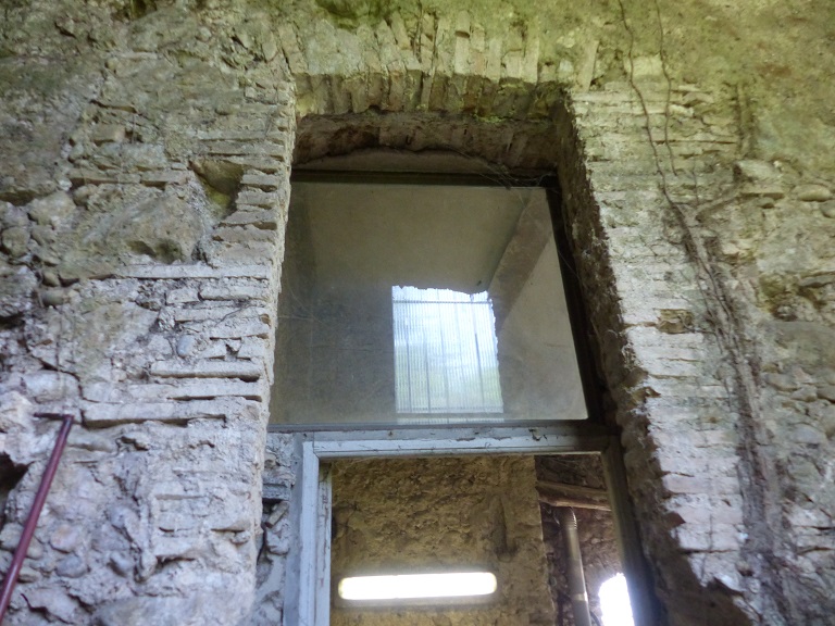 Entrepôt agricole 2. Elévation nord, premier niveau. Ancienne baie en brique convertie en porte. 