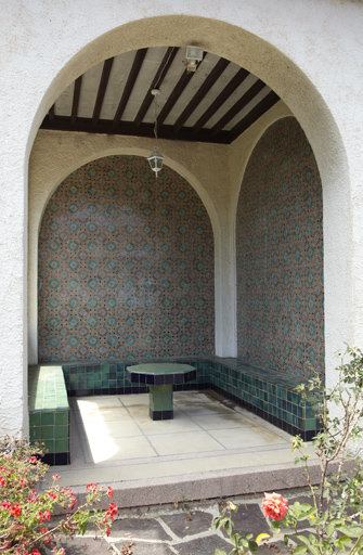 Salon d'extérieur, aux murs carrelés, donnant dans le patio.