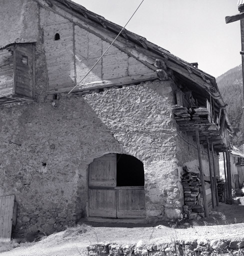 Façade nord. Partie droite. Porte de la grange et buchère suspendue le long de la façade ouest.