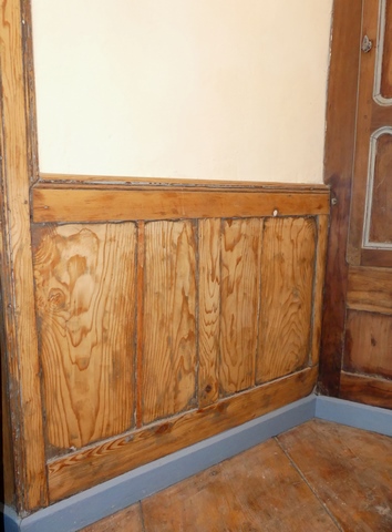 Rez-de-chaussée surélevé, pièce nord. Lambris de demi-revêtement en bois.