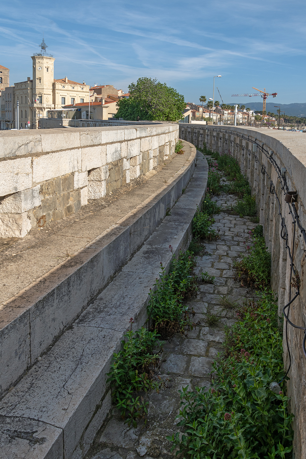 Vue intérieure plongeante du chemin de ronde crénelé de la caponnière de communication, prise du phare