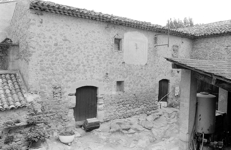 Cave A. Façade antérieure sur cour avec cadran solaire.