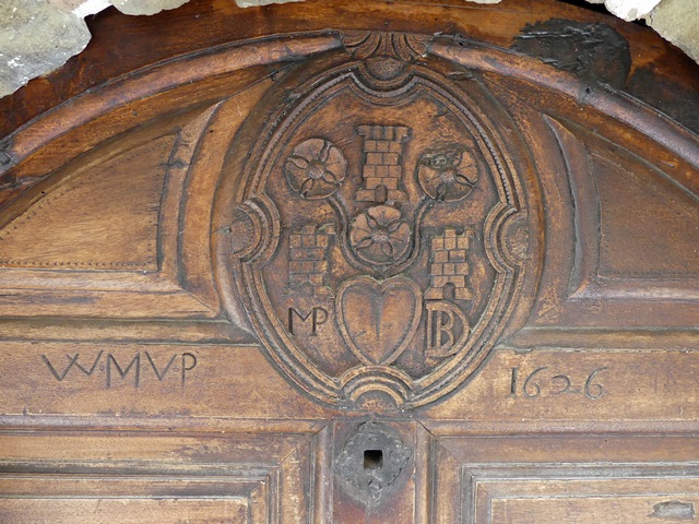 Elévation nord, premier niveau. Porte du logis, menuiserie ornée de symboles en réserve (trois roses et trois tours sur un cœur), d'initiales en réserve (DB), d'une date gravée (1626) et d'initiales gravées (MP / VV MVP).