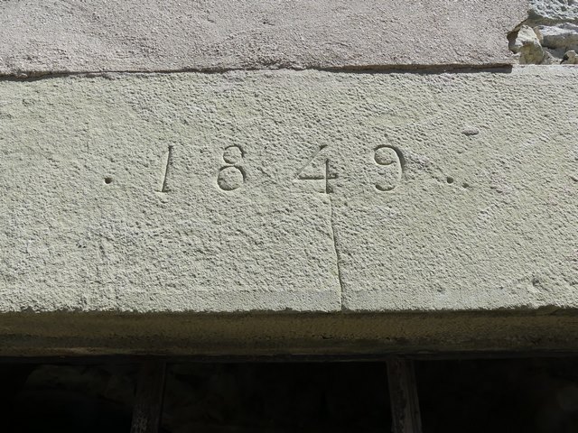 Elévation sud, premier niveau. Porte du logis, linteau avec date gravée (1849).