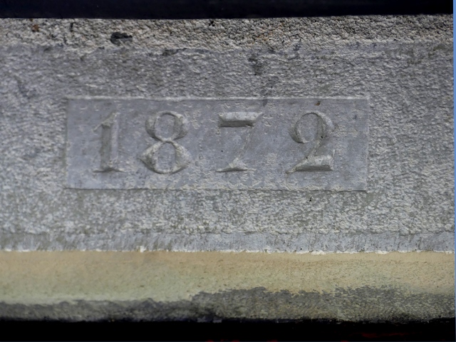 Pignon sud, deuxième niveau. Porte du logis : date gravée (1872).