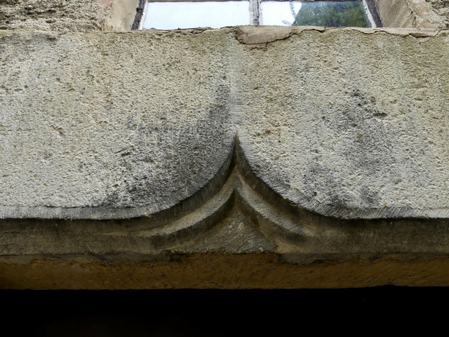 Elévation ouest, premier niveau. Porte du logis, avec linteau à double accolade en remploi. Détail.