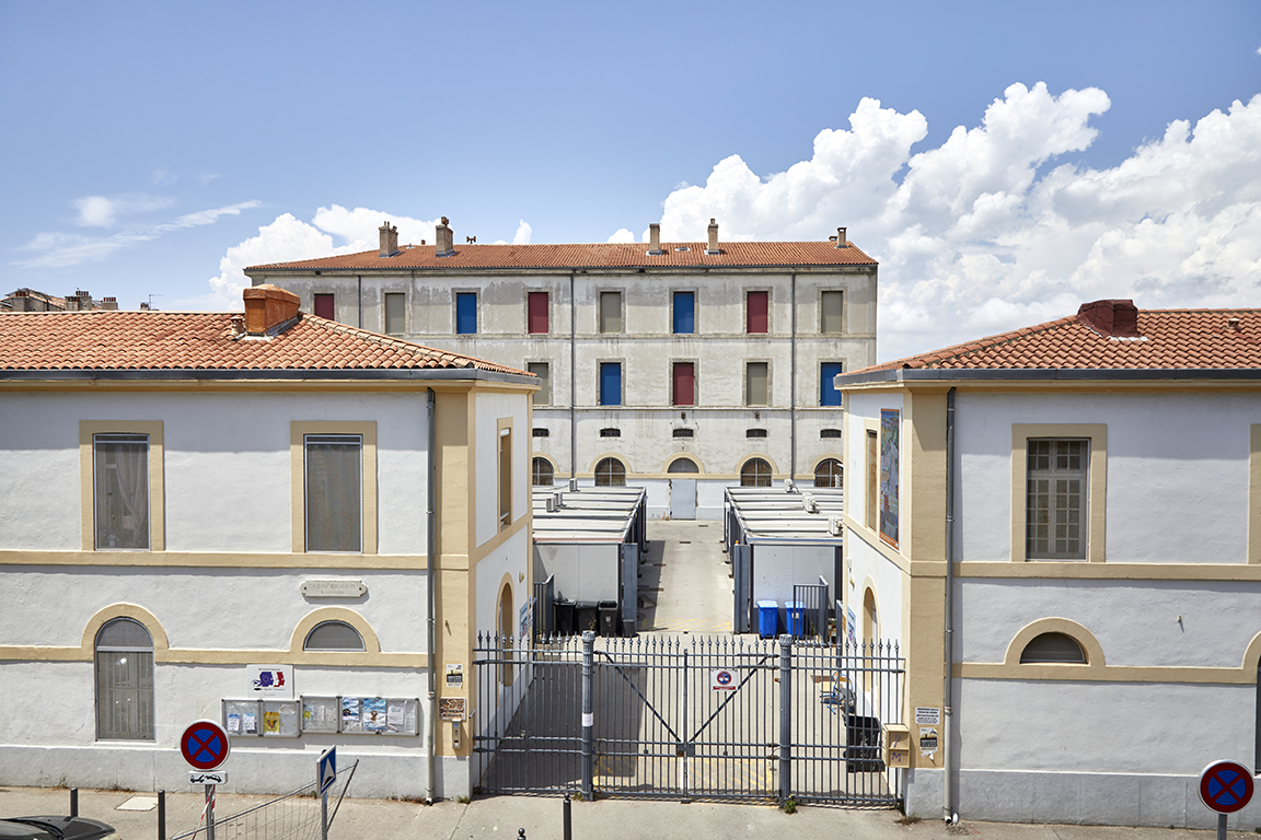 Grille d'entrée, pavillons et, en fond de cour, bâtiment principal.