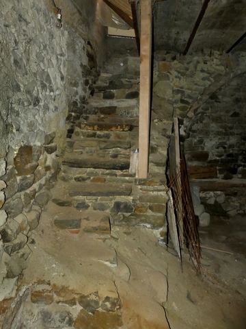Premier étage de soubassement, cellier-étable. Mur sud et escalier menant au second étage de soubassement.