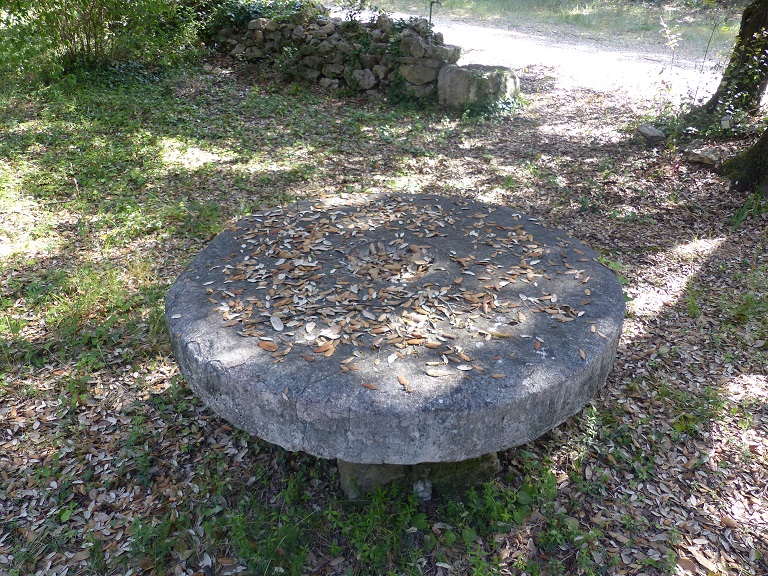 Jardin à l'est de la ferme. Ancienne meule issue d'un moulin à huile convertie en table . 