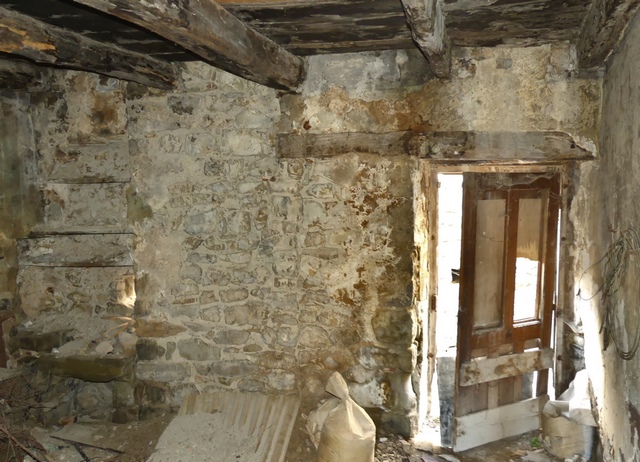 Rez-de-chaussée surélevé, cuisine. Mur ouest, porte et niche de la pile d'évier.