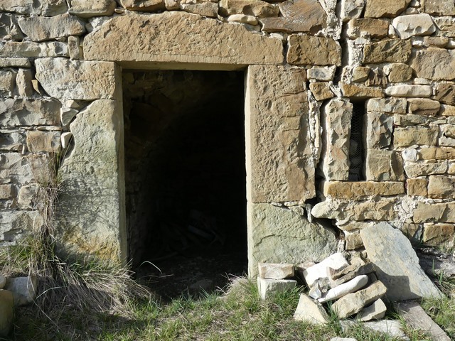 Pignon sud, premier niveau. Porte et jour en fente de la resserre-cellier.