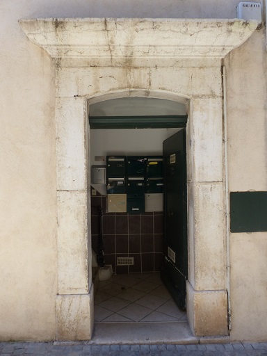 Maison à la Haute-Gaude, rue Centrale. Porte du logis avec encadrement en pierre de taille en un arc segmentaire surmonté d'une corniche moulurée. 