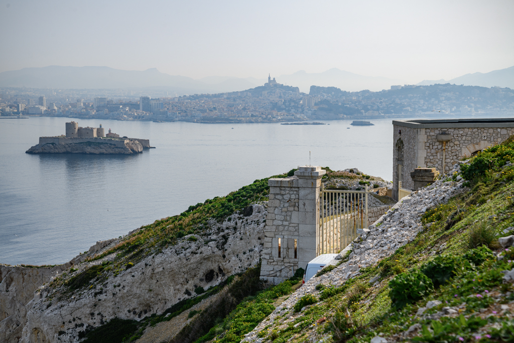 Front nord, vue plongeante de la porte du fort et premier bâtiment militaire (a) prise depuis l'intérieur au fond, le château d'If