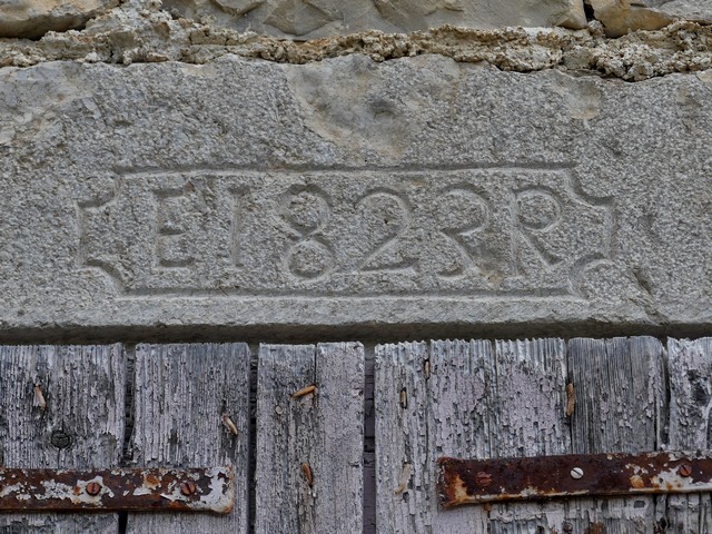 Pignon sud, deuxième niveau. Fenêtre, cartouche avec une date gravée (1823) accompagnée d'initiales (E I / R).