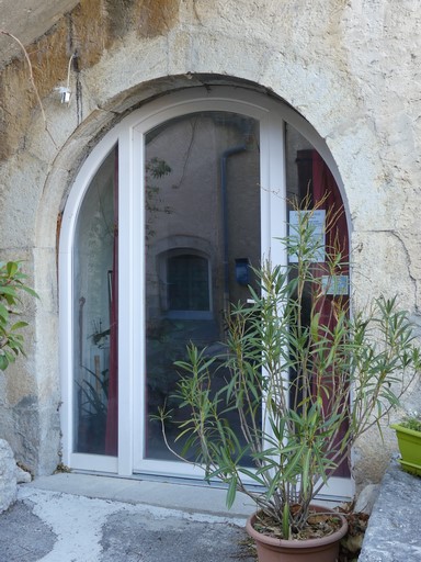 Dépendance est. Bâtiment nord, pignon est. Premier niveau, porte charretière en arc plein-cintre.